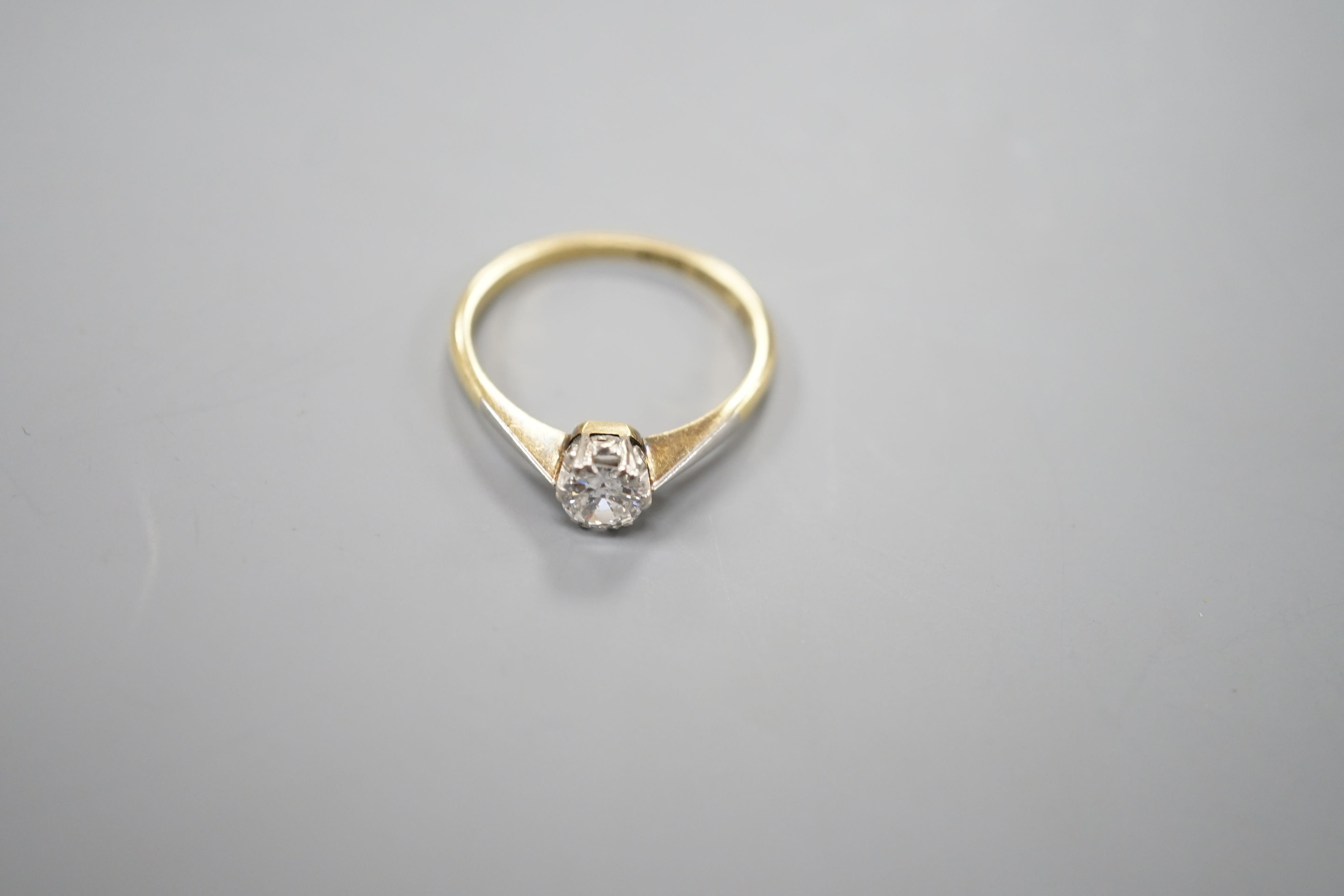 An 18ct gold and platinum solitaire diamond ring, the brilliant cut stone approximately 0.35cts, size M, gross 2.5 grams